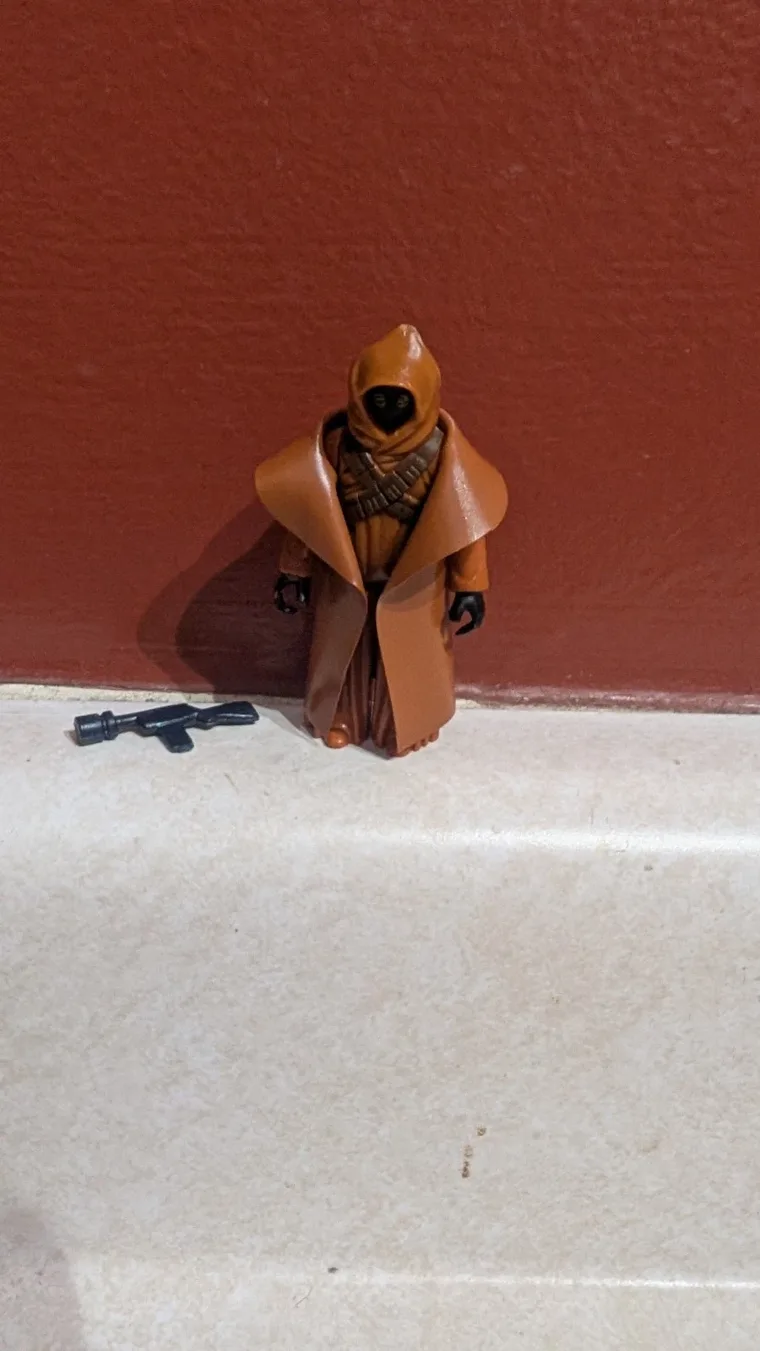 Vinyl-cape Jawa, front view, blaster on the ground beside it